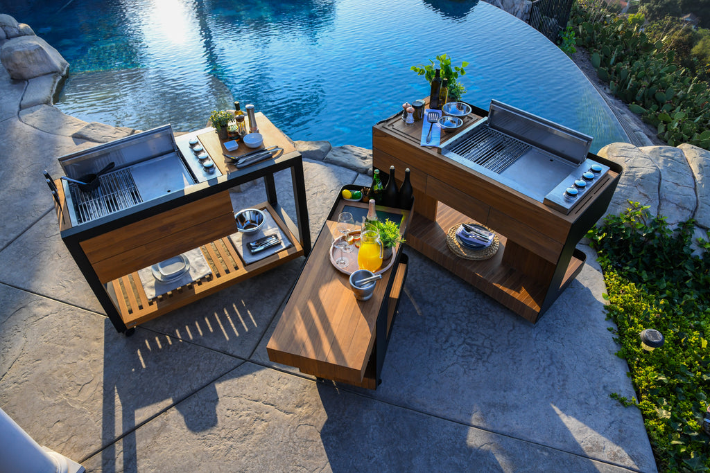 Top shot of Indu+ Bar Isle, Bistro Island, and Grill Island by the pool. Versatile and stylish outdoor cooking solutions with ample cooking, preparation, and serving space. Elevate your outdoor gatherings with these functional and beautifully designed carts, perfect for creating unforgettable culinary experiences.